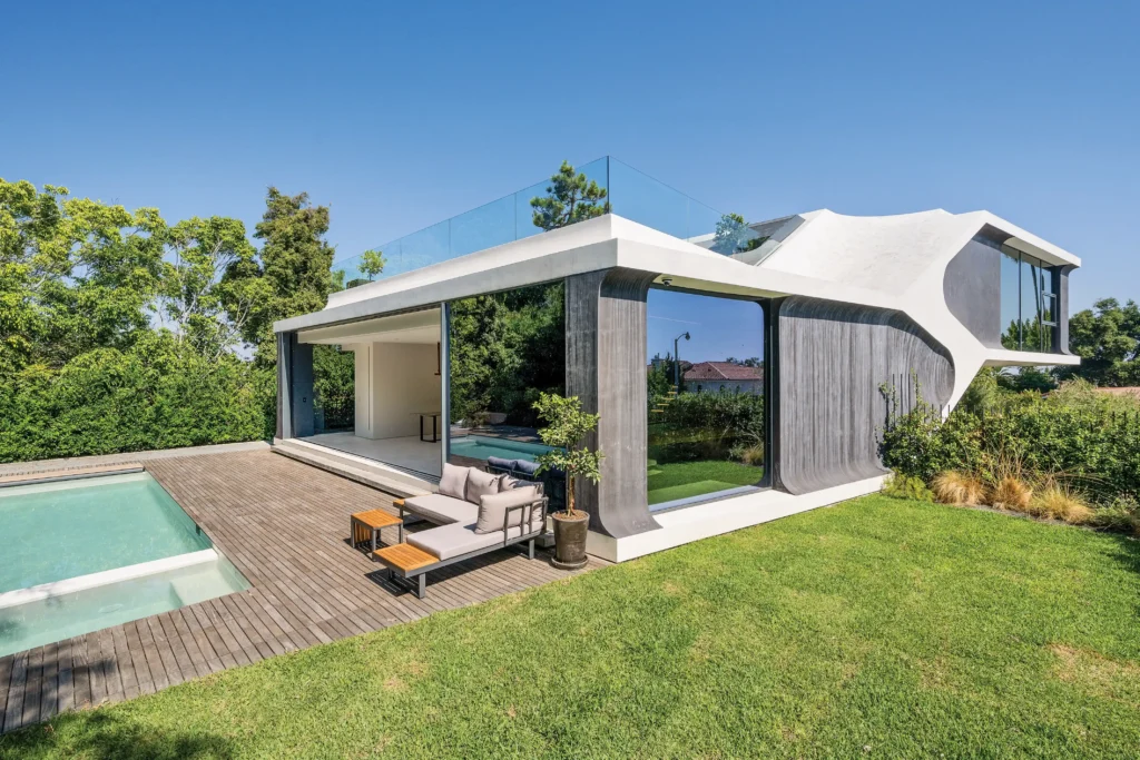 A stylized render of a modern 3D printed luxury home with clean architectural lines, spacious open design, and sustainable materials on display.