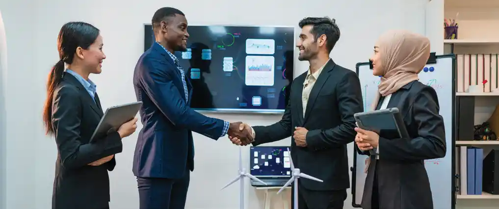 Two professionals shaking hands across a table after a successful meeting, symbolizing trust and partnership.